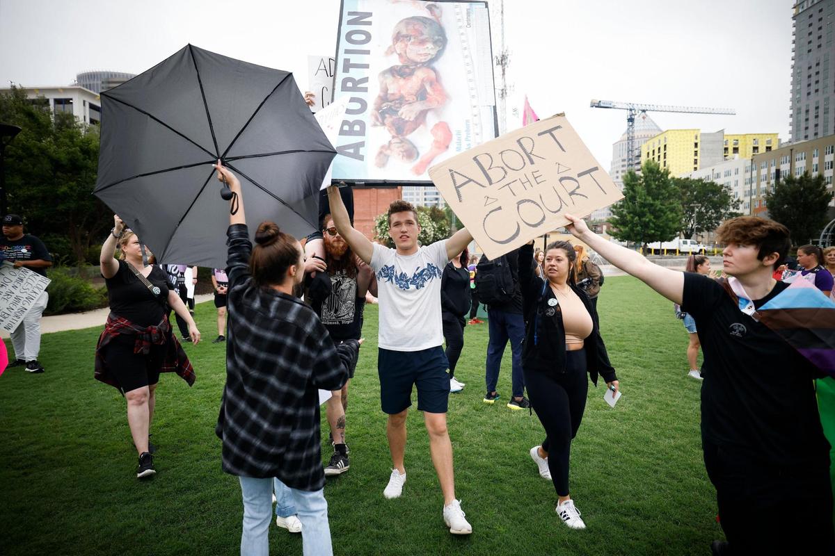 Abortion rights demonstrators attempt to block Ethan Metzger, of Charlotte, N.C., who is carrying a sign depicting an aborted fetus during a rally at First Ward Park in Charlotte, Sunday, July 10, 2022.