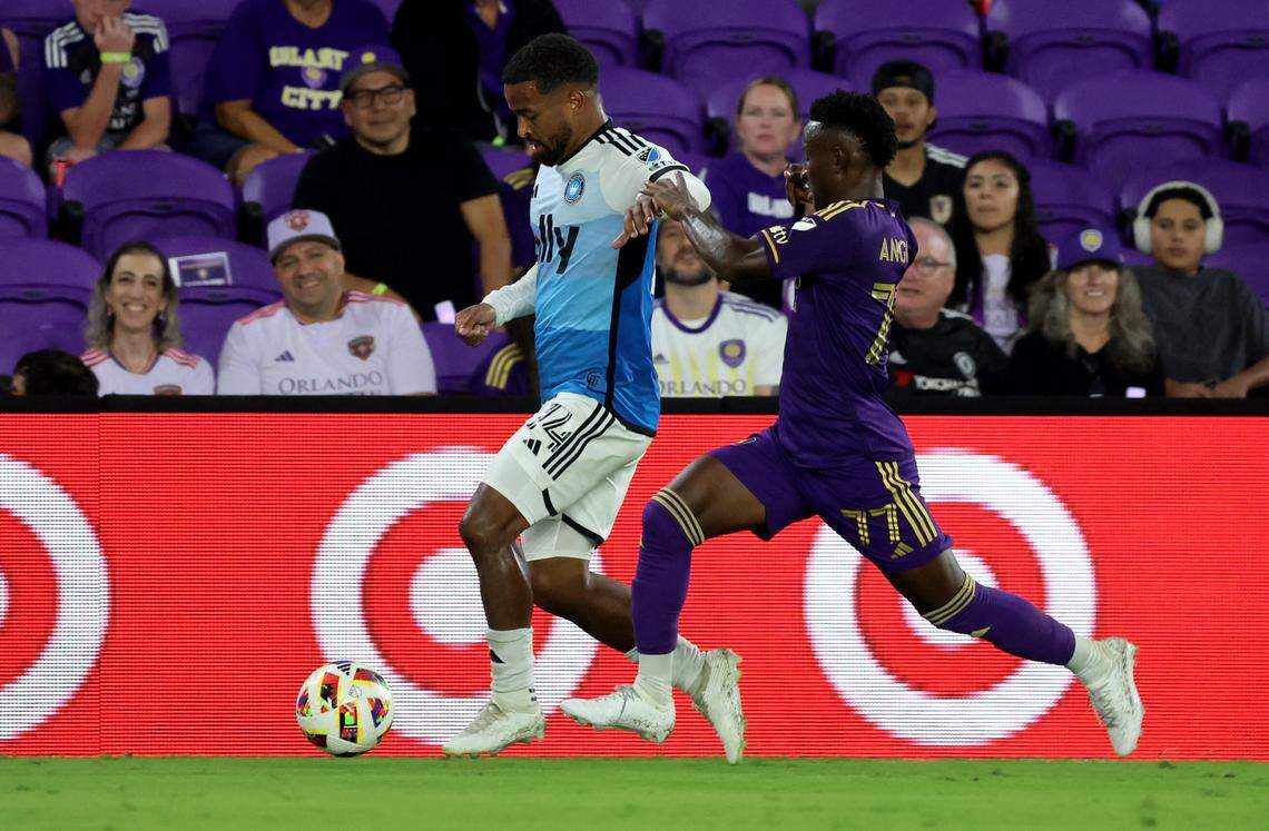Charlotte FC defender Nathan Byrne (14) dribbles against Orlando City midfielder Ivan Angulo (77) during the first half in a 2024 MLS Cup Playoffs Round One match at Inter&Co Stadium. Kim Klement Neitzel-Imagn Images