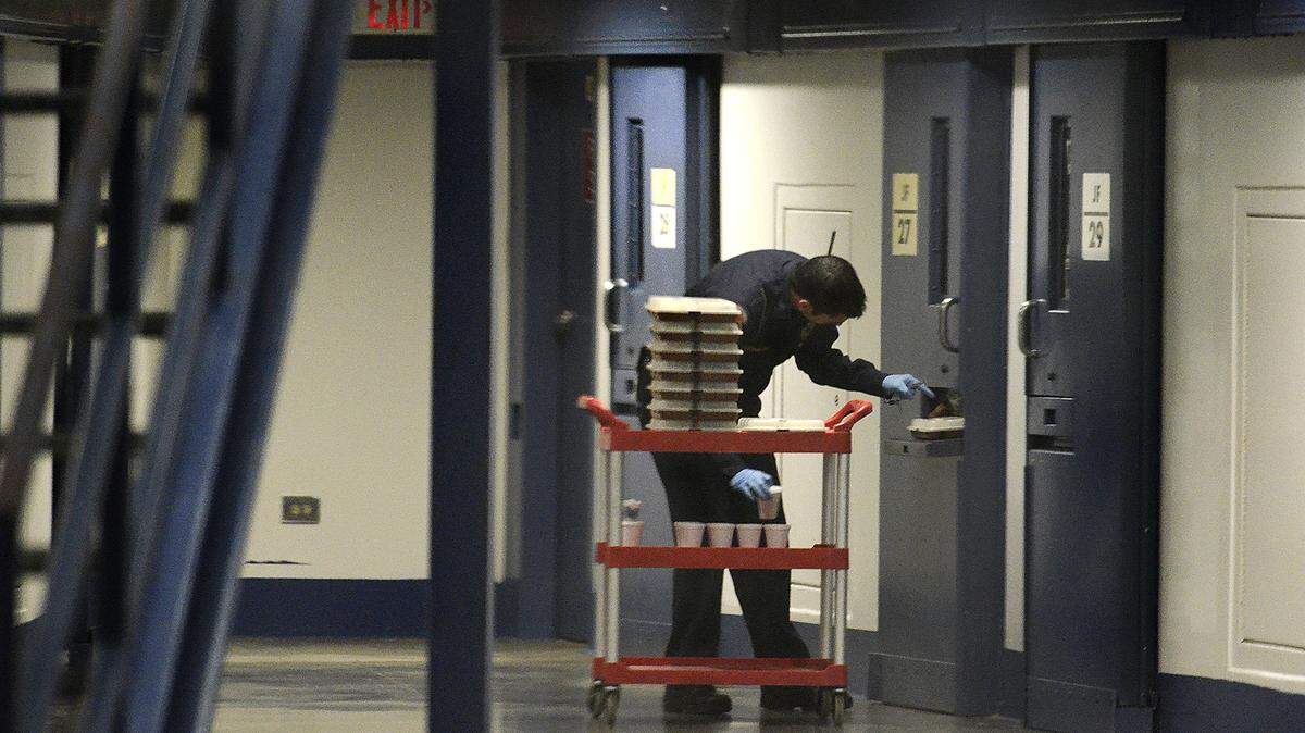 A correctional officer delivers food to inmates in a medium custody cell block at Lanesboro Correctional Institution.