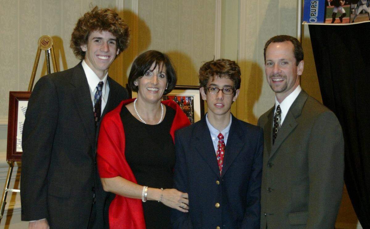 Kyle Kallander, right, takes a photo with his family, including his wife, Lisa, and two sons, Stefan and Tristan.