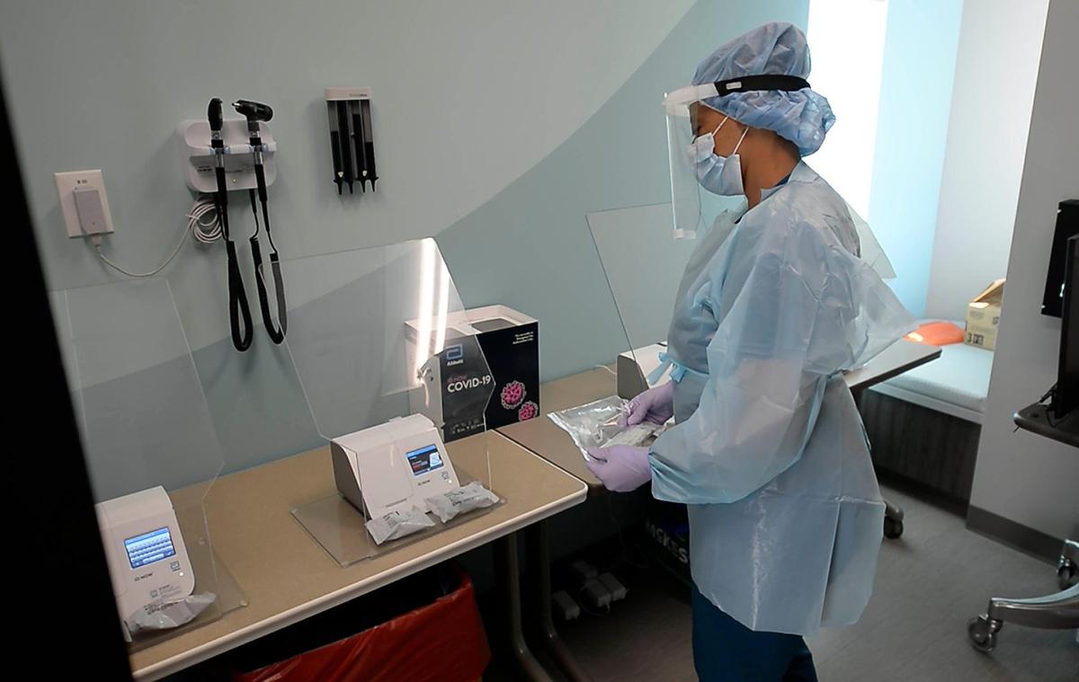 Lab Technician Tracie Gardner runs COVID-19 tests through Abbott ID NOW COVID-19 rapid test machines while at the Michael Jordan Family Medical Clinic in Charlotte on Friday, July 31, 2020. The machines can detect COVID-19 in 13 minutes or less.