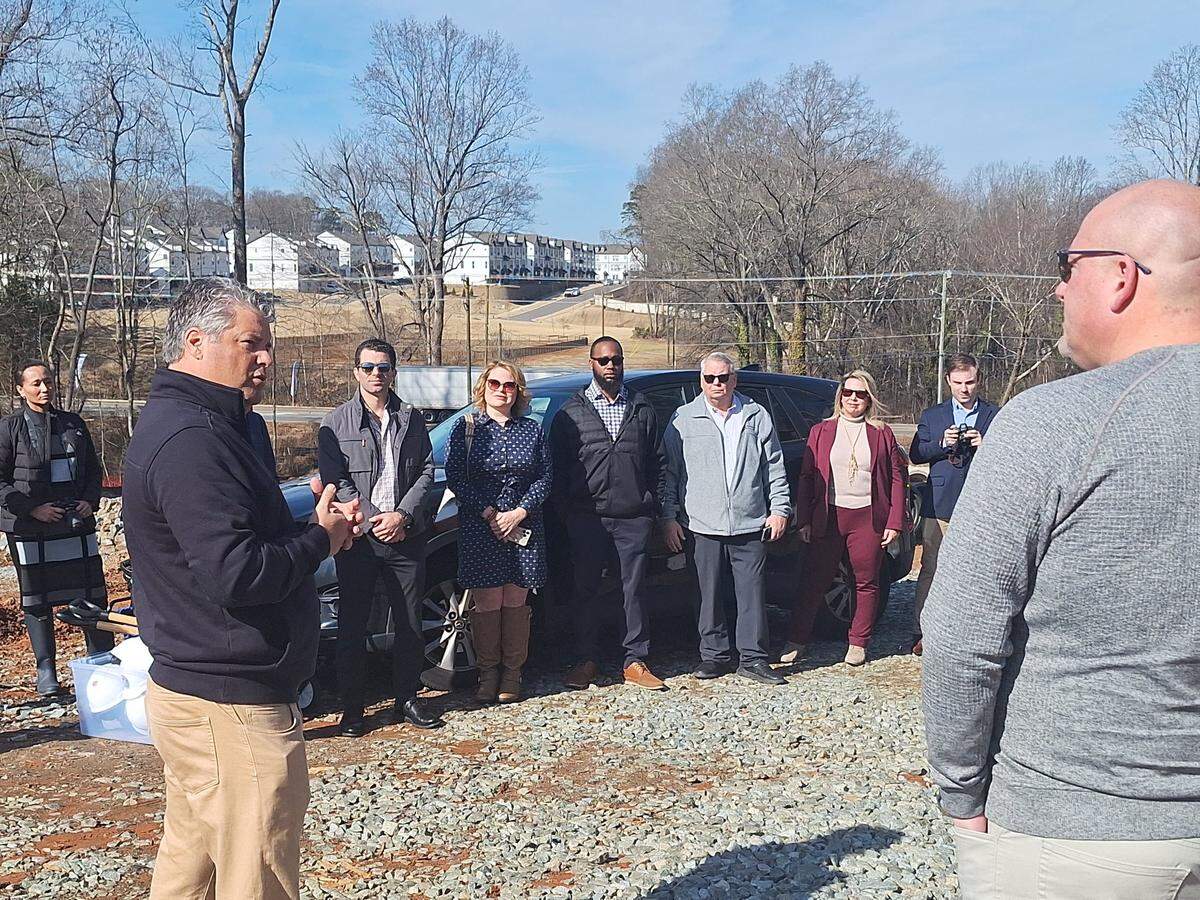 Mooresville Mayor Chris Carney, left, addresses project officials at an east-west traffic-reliever connector road under construction at U.S. 21 and Deerwood Lane on Monday, Feb. 3, 2025. 