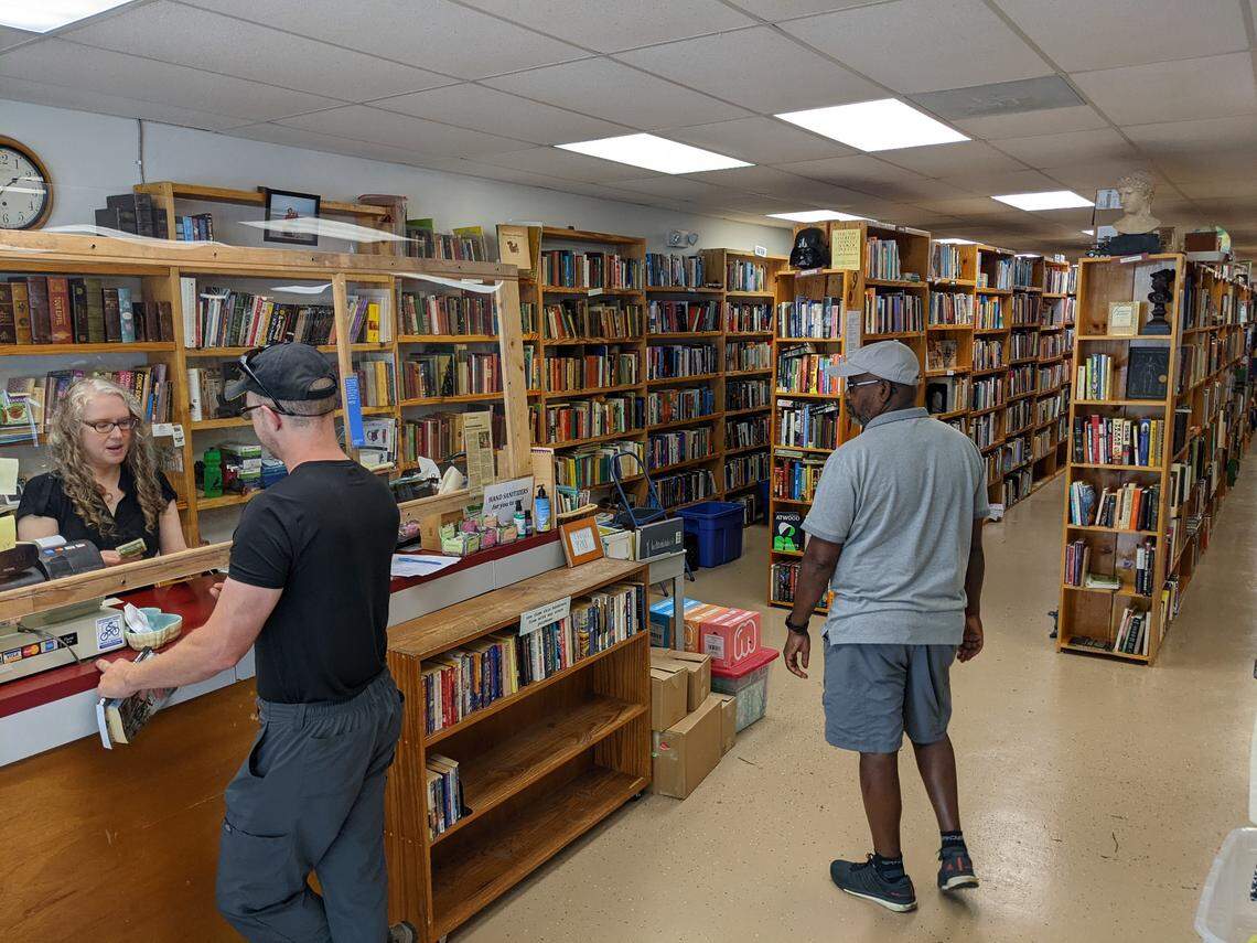 Lee Rathers, co-owner of Book Buyers used book store with dad Richard Rathers and wife Virginia O’Riley, checks out customers at the new store location at Eastway Crossing shopping center in Charlotte.