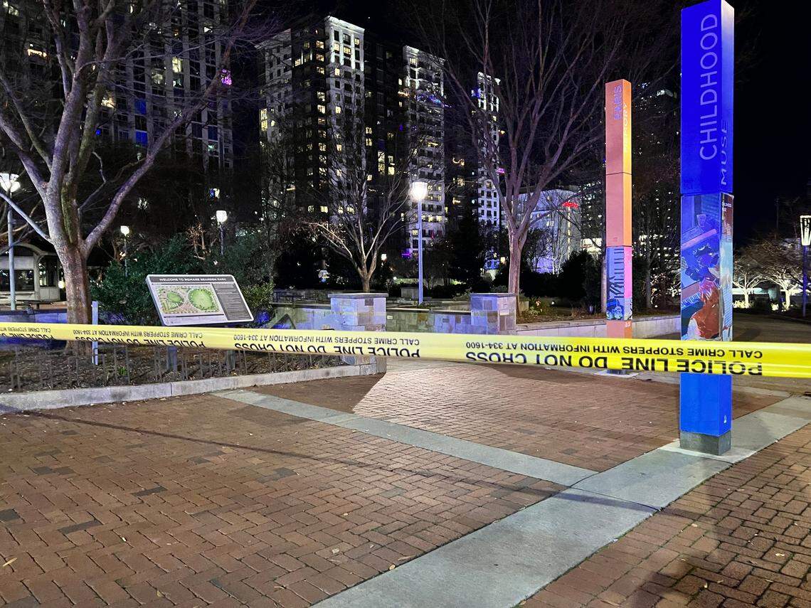 Crime scene tape stretches across Romare Bearden Park after a New Years Eve shooting injured several people. A 19-year-old man was arrested for the crime.