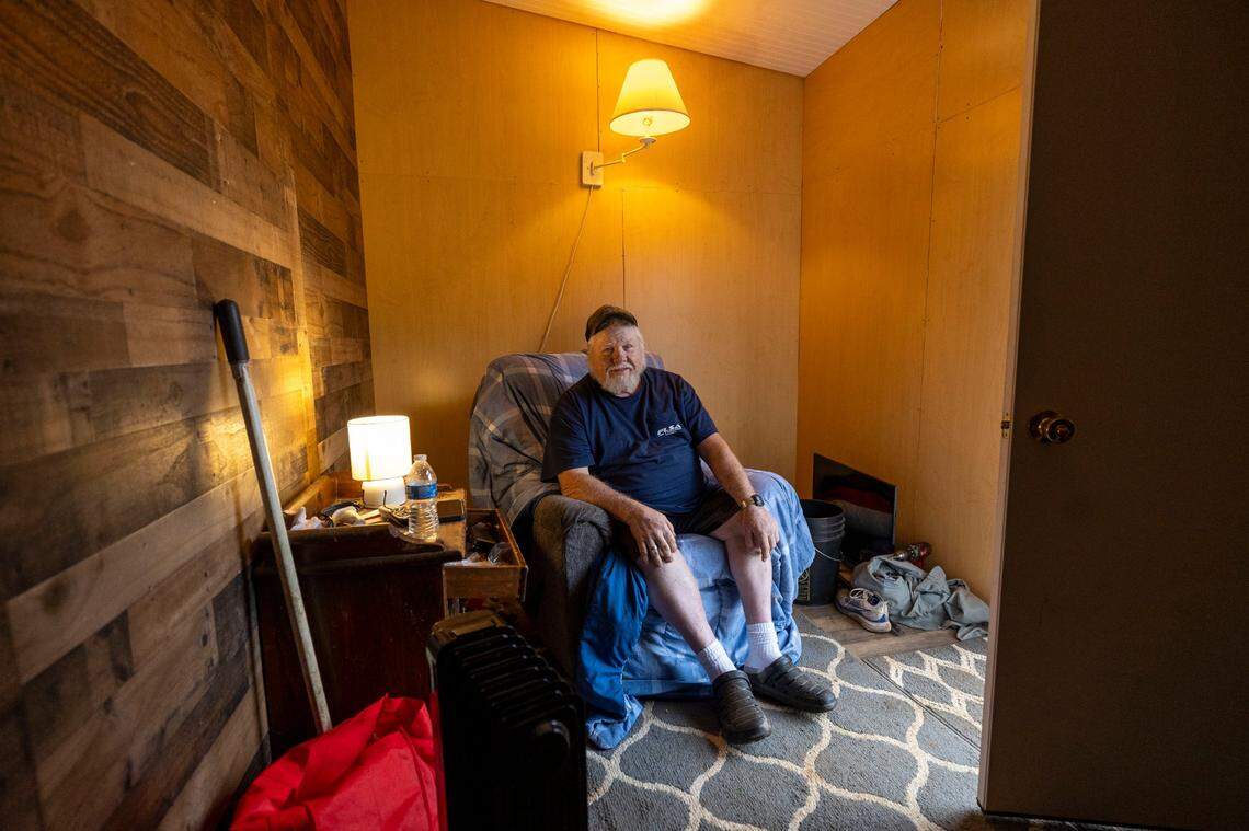 Thomas Whiteside sits inside a tiny, temporary home built by Cabins 4 Christ after Helene hit western North Carolina. The heated shelter allowed Whiteside to remain on his Black Mountain property after flooding left his home uninhabitable.