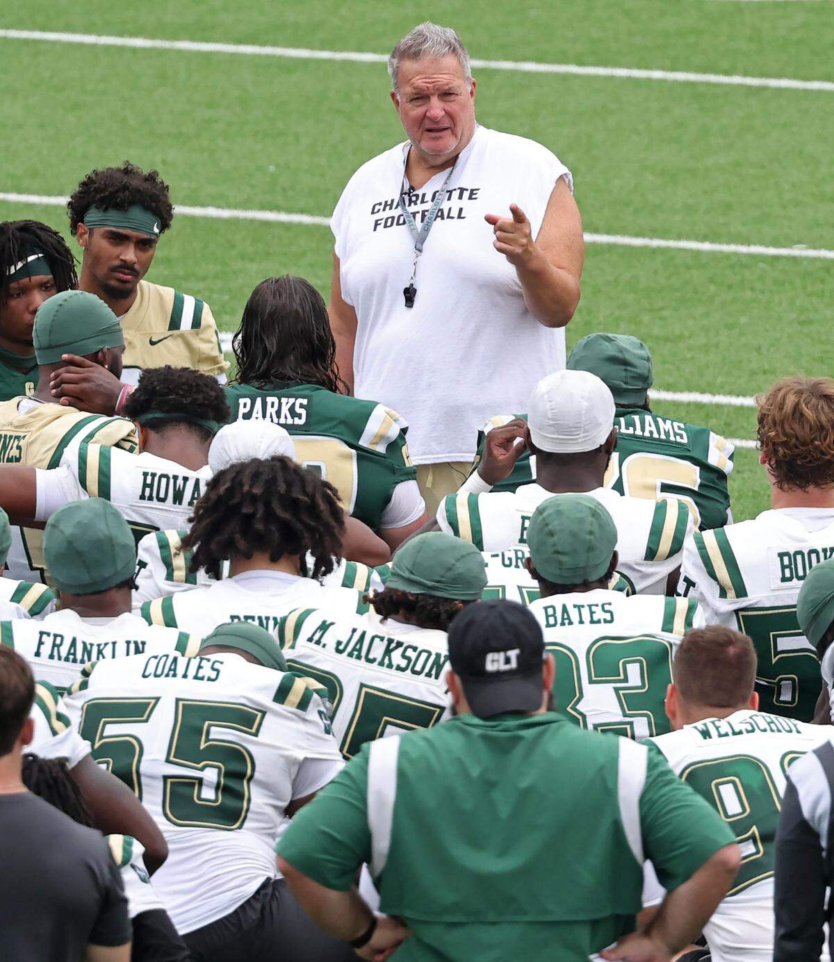 Charlotte 49ers head football coach Biff Poggi speaks to the team following practice.