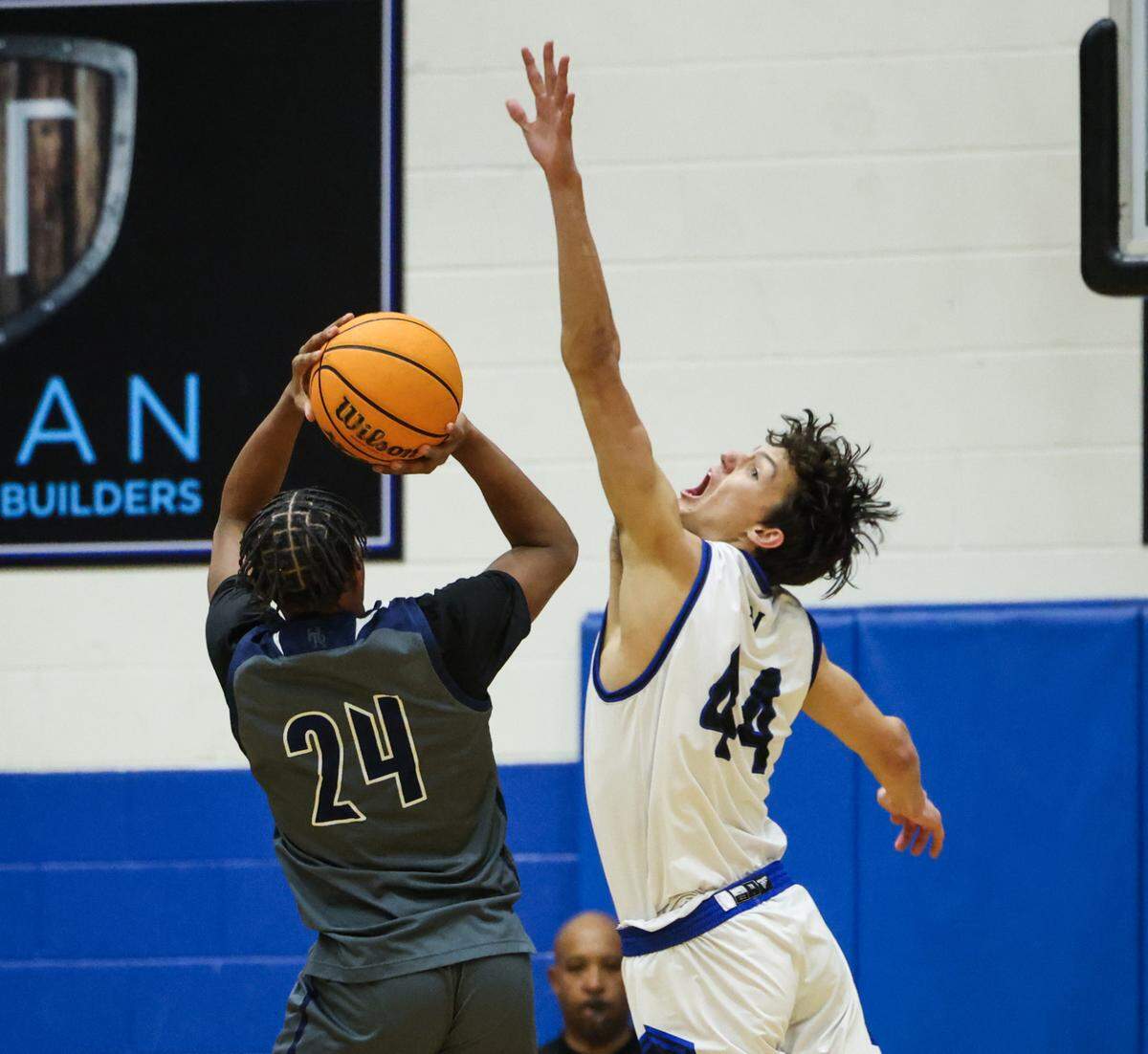 Hickory Ridge Ragin’ Bulls Travien Williams, left, shoots past a block by Lake Norman Wildcats Trent Steinour at Lake Norman High School in Mooresville, N.C., on Tuesday, February 6, 2024.