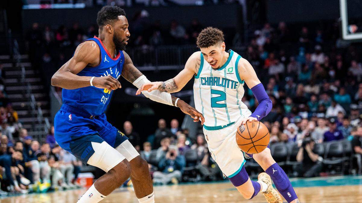 The Hornets’ point guard LaMelo Ball, right, drives the ball as Denver’s Jeff Green plays defense during the game at Spectrum Center on Monday, March 28, 2022 in Charlotte, NC. Denver won, 113-109.