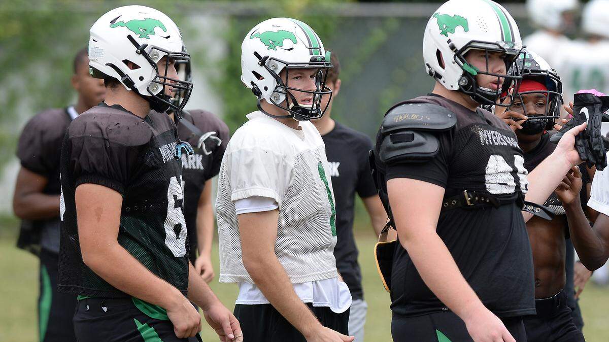 Lucas Lenhoff, center, was the Myers Park quarterback last season. He and his family moved to Charlotte last spring to play football at Myers Park, along with 10 other kids from California, Texas and Georgia.