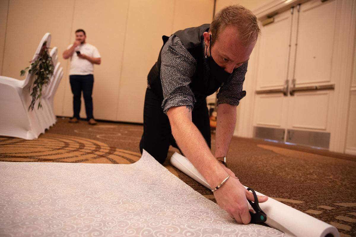 Trent Crumpler cuts the end of the aisle runner for the wedding of Cassidy Taylor and Gregory Hoffmann.