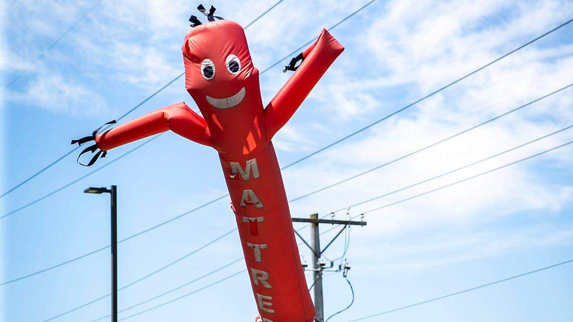 An inflatable tube blows in the air advertising a mattress sale at Midwest Mattress on Memorial Day, Monday, May 29, 2023, in Coralville, Iowa.