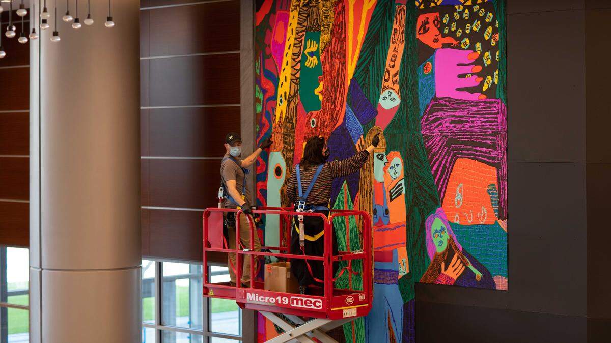 Artist Summer Wheat works on “Waterfalls.” The piece was installed in January at Lincoln Harris’ Legacy Union development in uptown. Equal parts painting, sculpture and textile, the artwork stands nearly 21 feet tall. 