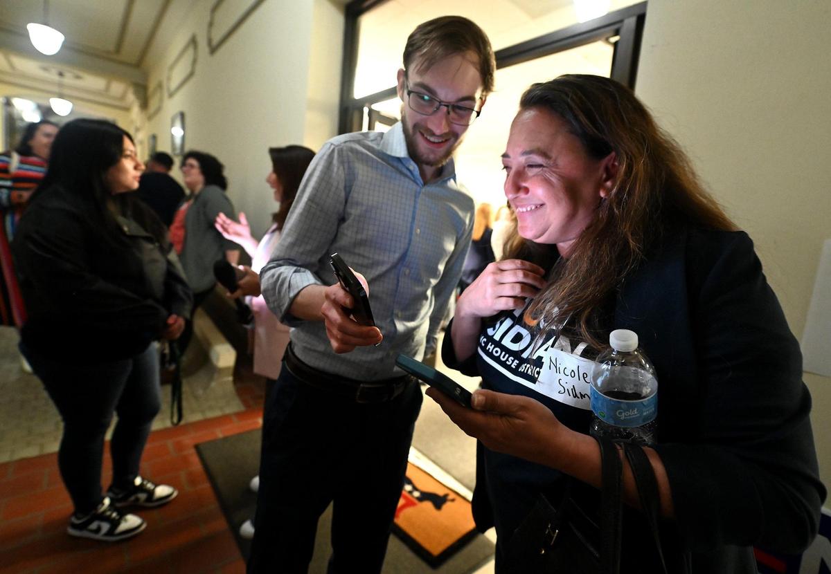 Nicole Sidman, right, and Drew Kromer, left, Mecklenburg County Democratic Party chair, smile as they look over election results on Tuesday, March 5, 2024.