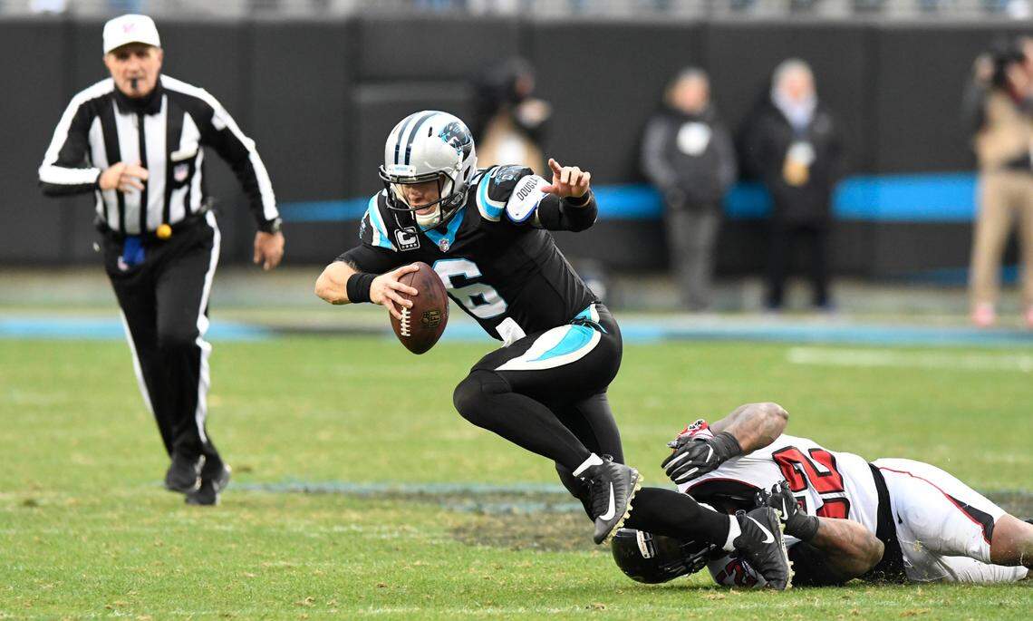 Carolina Panthers quarterback Taylor Heinicke (6) gets tripped up by Atlanta Falcons defensive end Bruce Irvin (52) during the second half at Bank of America Stadium in Charlotte, NC on Sunday, December 23, 2018. The Falcons won 24-10.