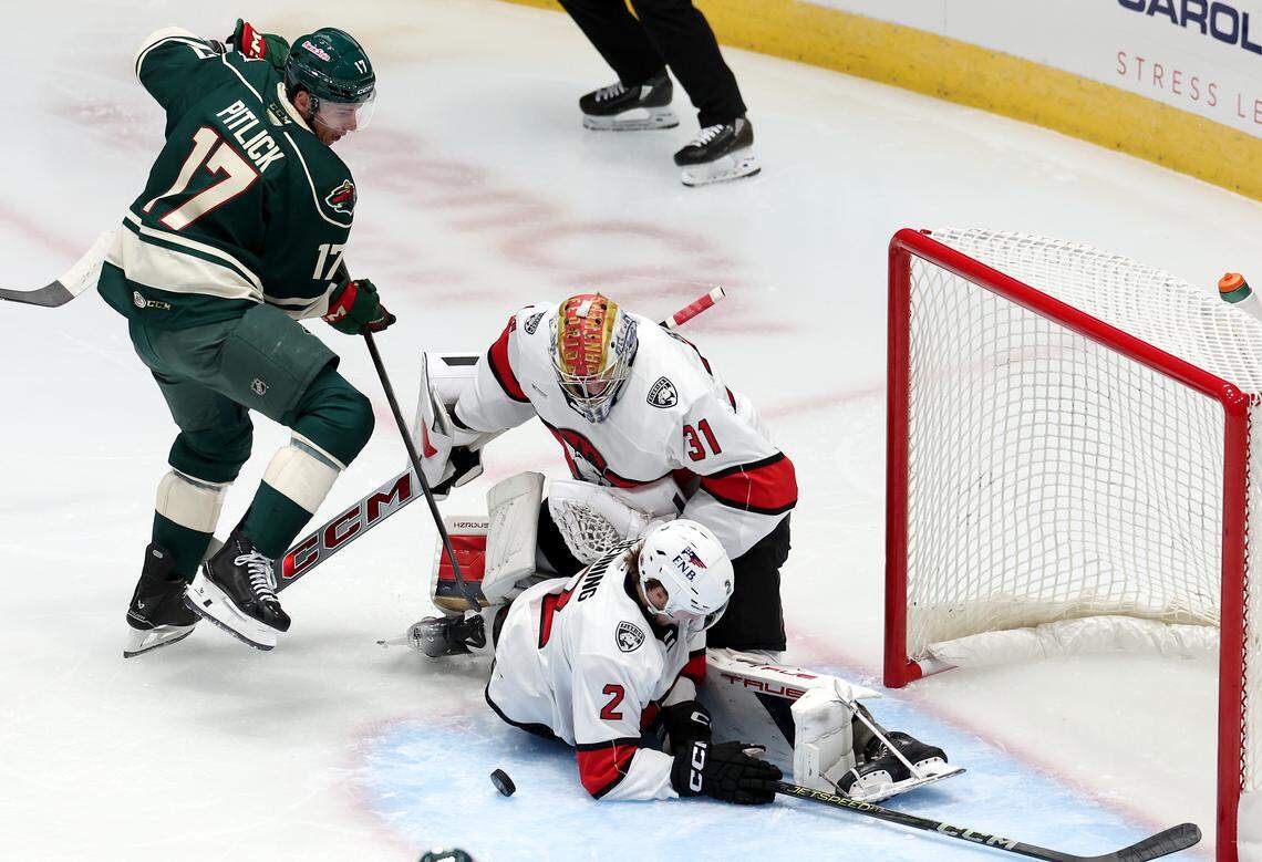 Charlotte Checkers goalie Cooper Black, center and Mike Benning, bottom/center, stop a shot on goal by the Iowa Wild’s Tyler Pitlick, left, during first period action on Friday, October 17, 2025 at Bojangles Coliseum in Charlotte, NC. 