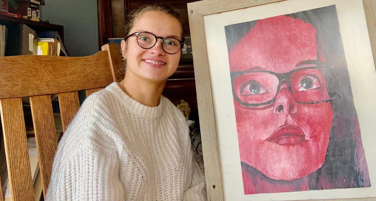 Gaila Fosbinder, 18, with a self-portrait she painted. “When my arm got tired of painting, I just put the paintbrush in my mouth and kept going,” she said. Fosbinder, of Charlotte, is one of the world’s top junior wheelchair tennis players.