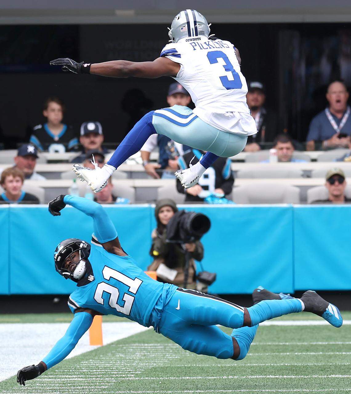Carolina Panthers safety Nick Scott, bottom, is unable to make the tackle on leaping Dallas Cowboys wide receiver George Pickens during Sunday’s game in Charlotte.