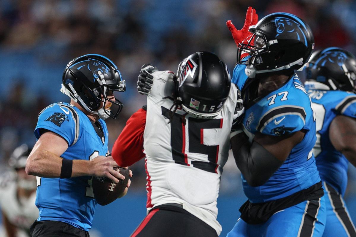Panthers quarterback Andy Dalton, left, evades being sacked as offensive lineman Yosh Nijman, right, holds off Falcons linebacker Matthew Judon during the game at Bank of America Stadium in Charlotte, NC on Sunday, Oct. 13, 2024.