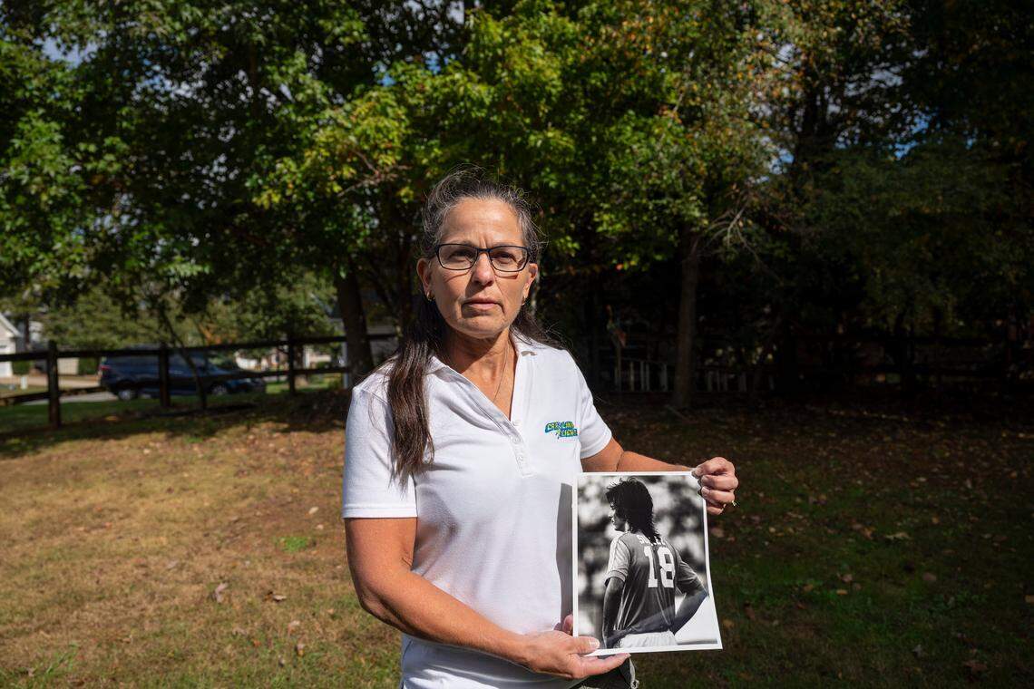 Ana Suarez Fleming poses for a portrait outside her home holding a photo of her brother, the late Carolina Lightnin’ soccer star Tony Suarez, on Friday, October 29, 2021 in Monroe, NC.