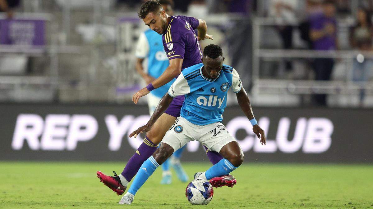 Charlotte FC defender Harrison Afful (25) in action against Orlando City SC midfielder Martín Ojeda (11) during the first half at Exploria Stadium. 