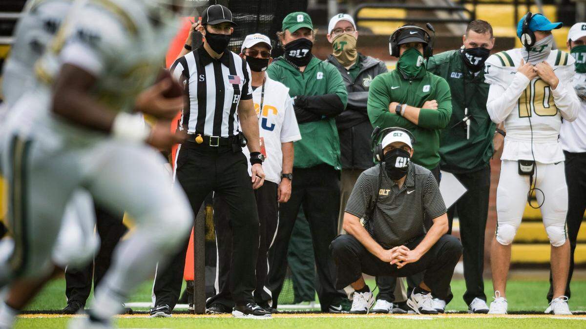 Charlotte coach Will Healy (crouching) watches his team from the sidelines in the second half of their game against Appalachian State on Sept. 12.