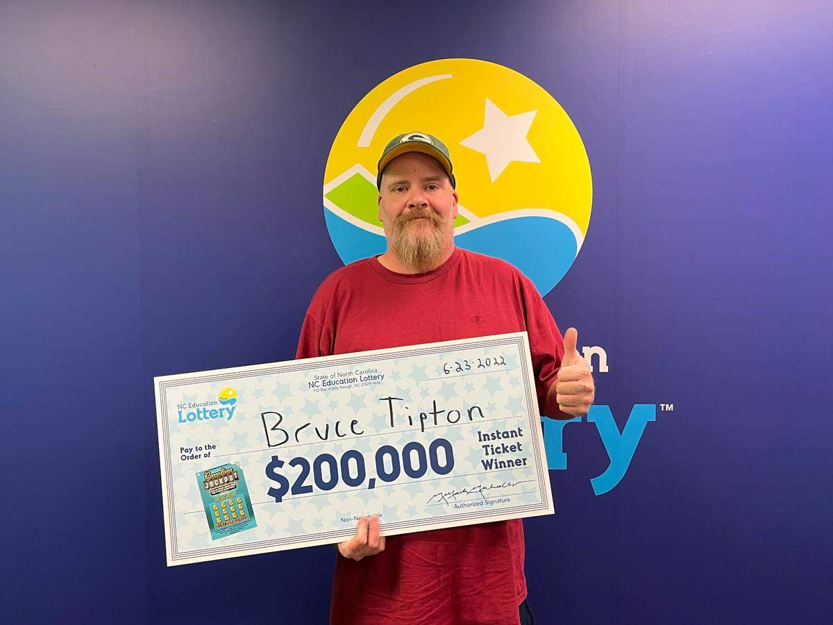 Bruce Tipton, 41, of Charlotte won the top $200,000 prize in the new $5 Carolina Jackpot game. He went to North Carolina Education Lottery headquarters in Raleigh to claim his prize on Thursday, June 23.