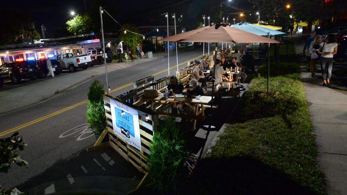 Diners enjoy meals and beverages Saturday along Thomas Avenue in Charlotte. The city of Charlotte launched its StreetEats program in Plaza Midwood during COVID-19, extending outdoor dining into parking and other spaces to help restaurants.