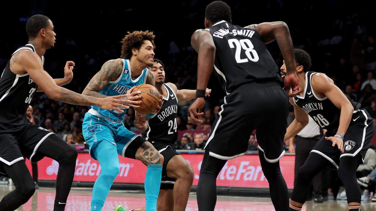 Mar 5, 2023; Brooklyn, New York, USA; Charlotte Hornets guard Kelly Oubre Jr. (12) drives to the basket against Brooklyn Nets center Nic Claxton (33) and guard Cam Thomas (24) and forward Dorian Finney-Smith (28) and guard Spencer Dinwiddie (26) during the second quarter at Barclays Center. Mandatory Credit: Brad Penner-USA TODAY Sports