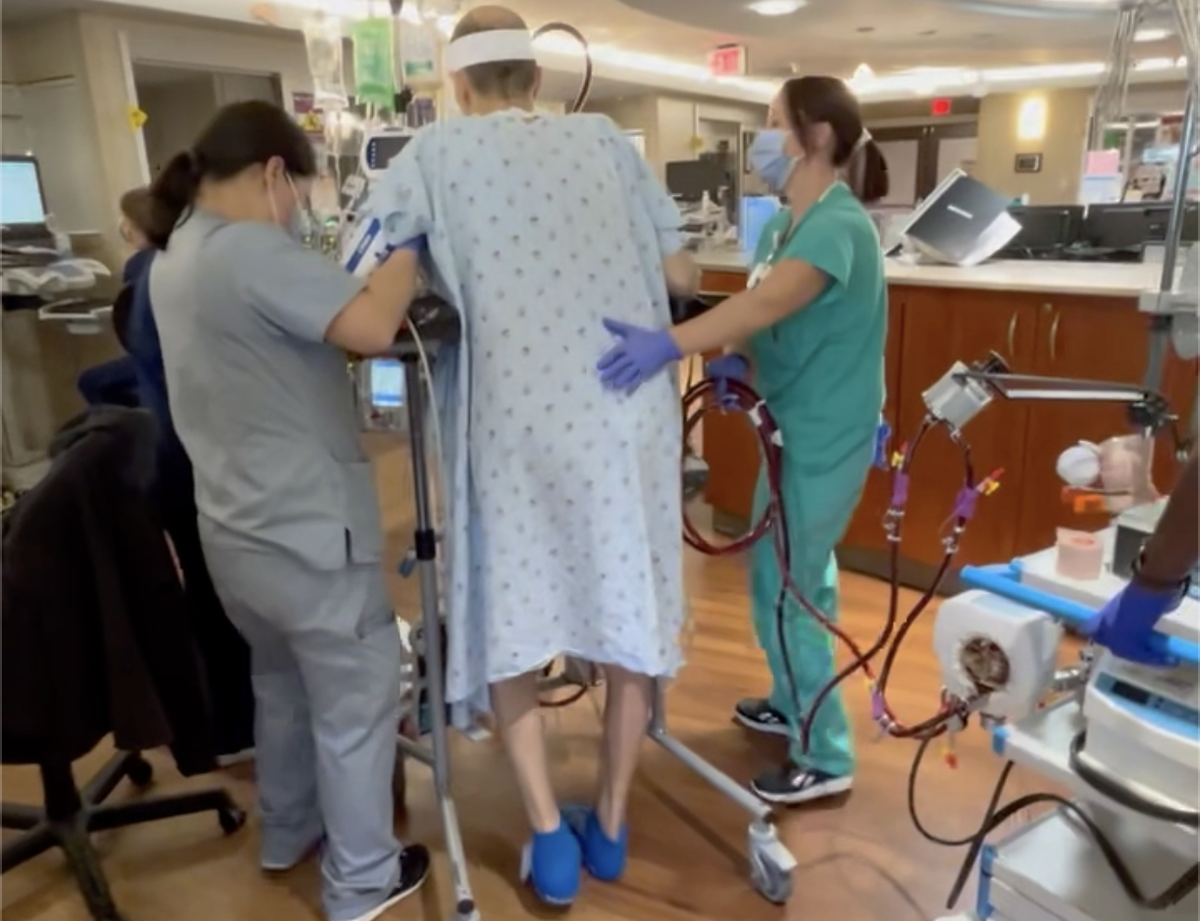 Kelvis Reid takes a walk through the ICU at the Sanger clinic with the help of nurses on staff.