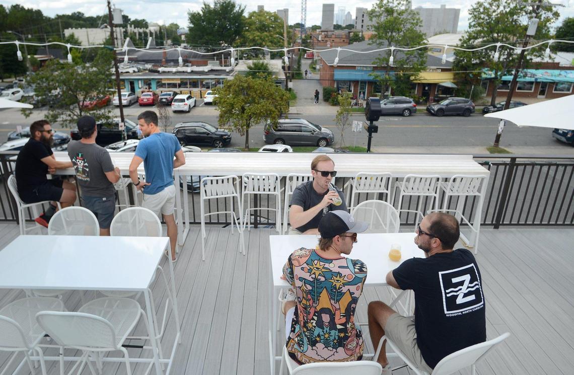 Burial Beer owner Doug Reiser (blue shirt) stands on his rooftop patio that no longer has a skyline view.