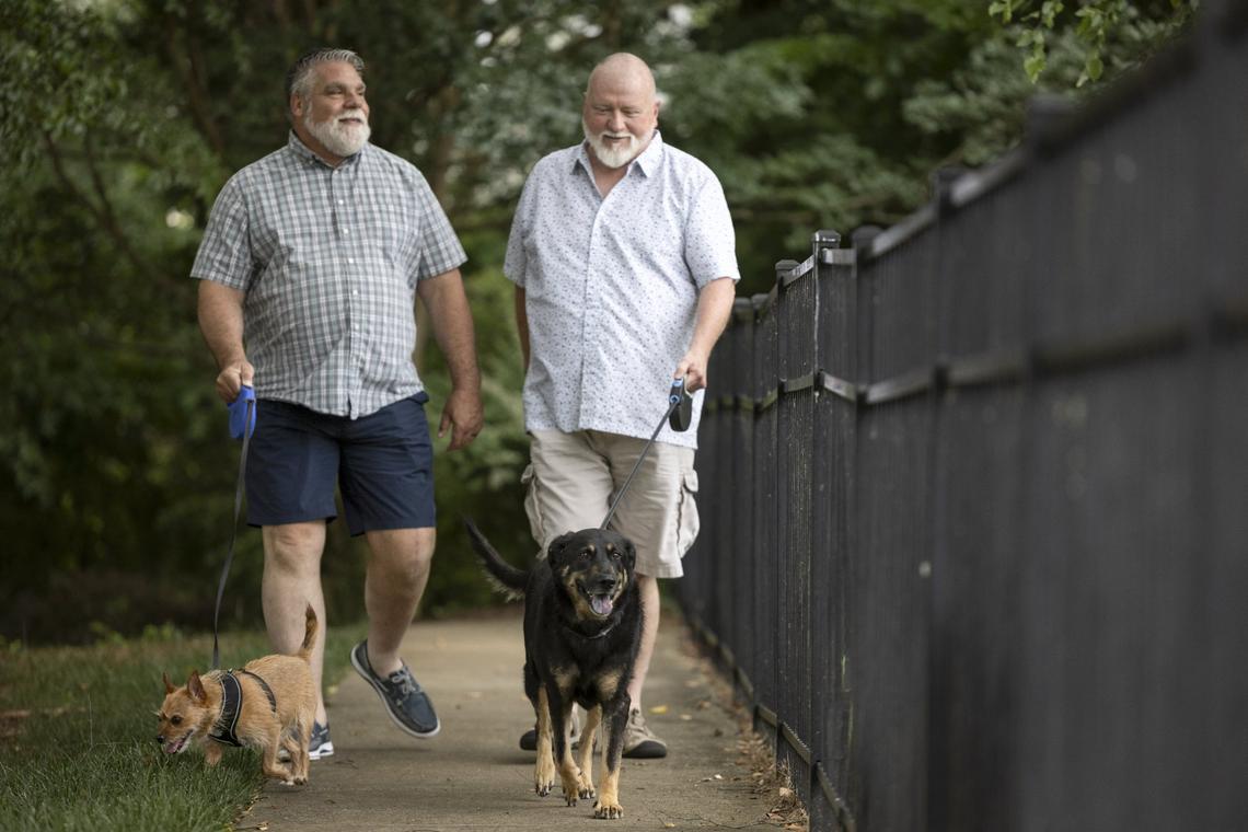 John Winn, left, and Steve Nichols walk with Oscar, right, and Harry in Indian Trail in early June. “They’re inseparable,” Nichols said about Oscar and Harry.