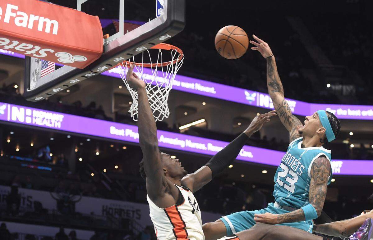 Charlotte Hornets guard Tre Mann (23) is fouled by Detroit Pistons center Jalen Duren (0) during the second half at the Spectrum Center. 