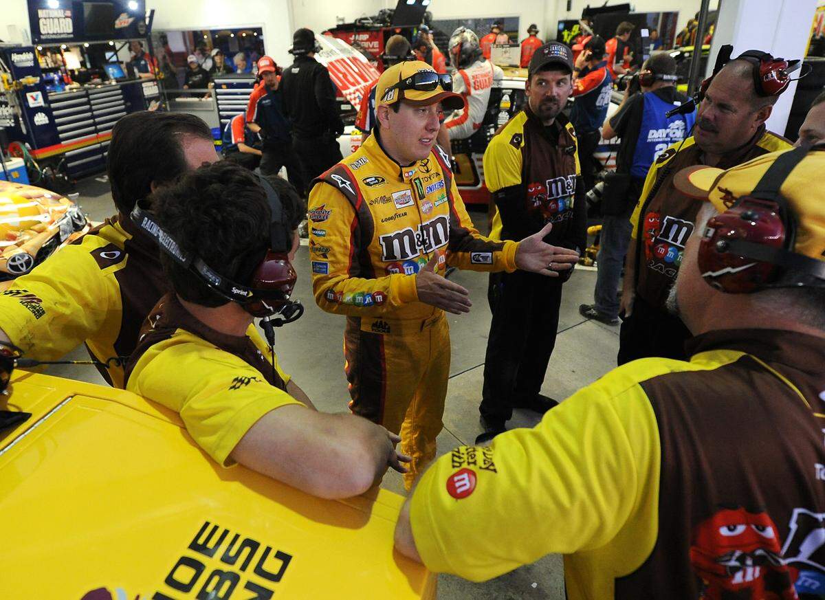 NASCAR Sprint Cup Series driver Kyle Busch (18) talks with members of his team on Wednesday, February 19, 2014 at Daytona International Speedway. 