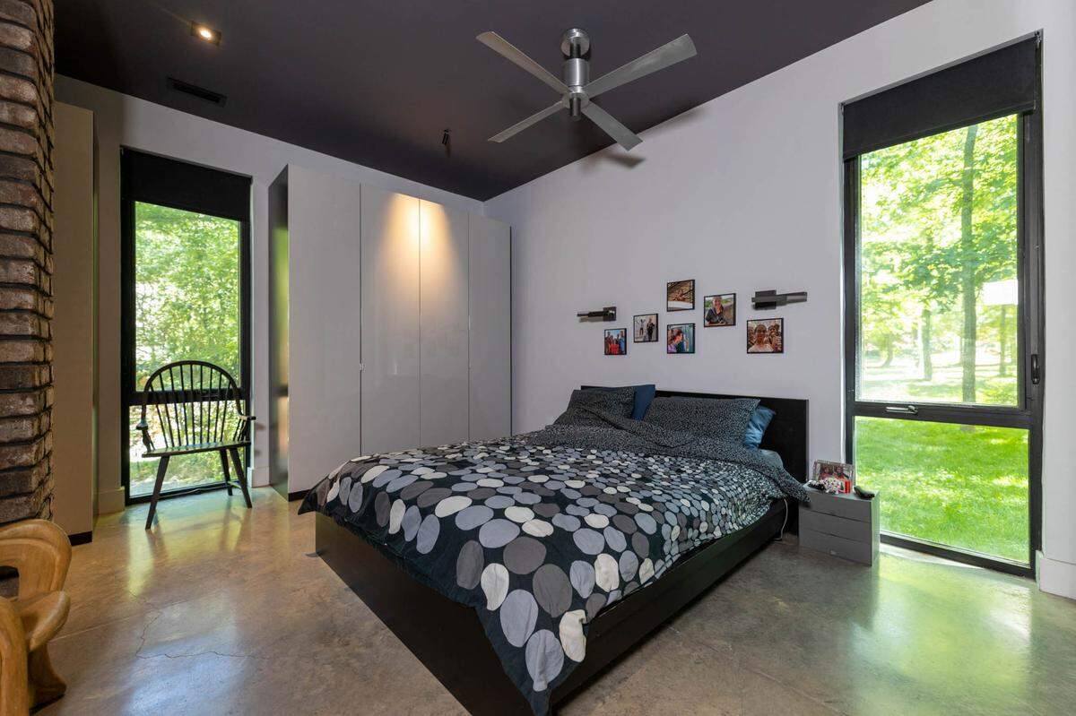 Oversized windows let the property’s trees have a presence inside the master bedroom.