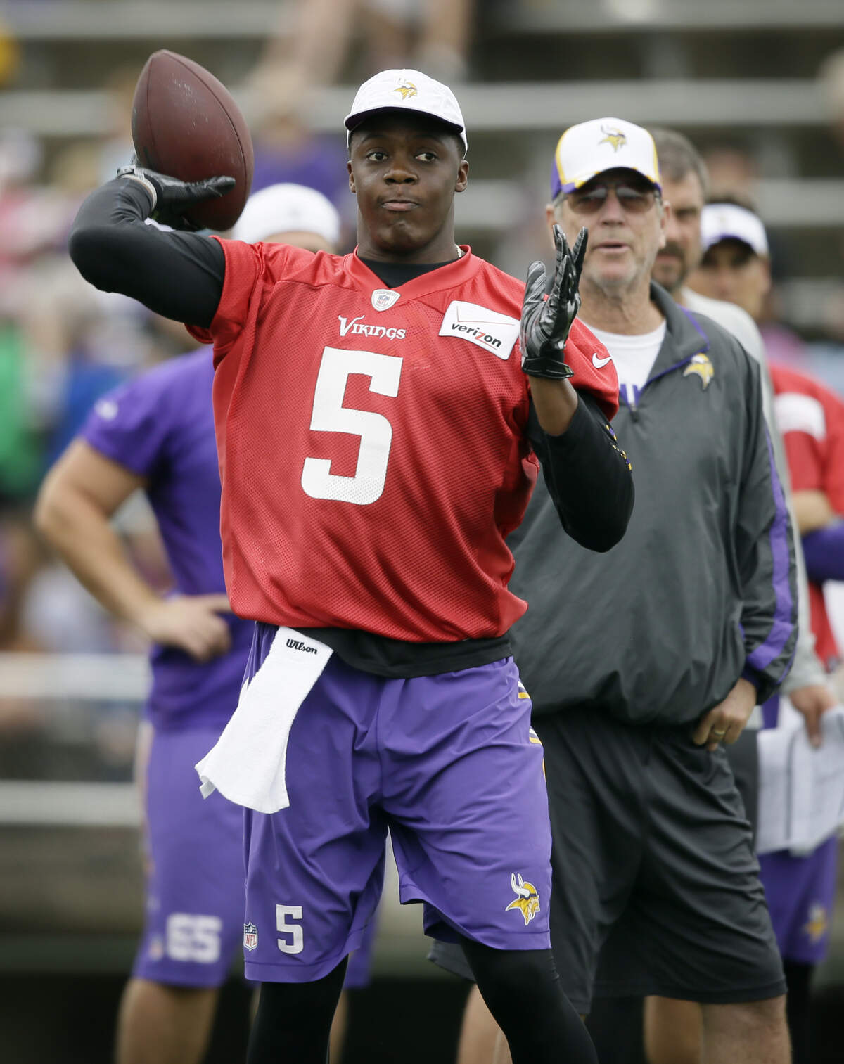 Minnesota Vikings quarterback Teddy Bridgewater throws a pass as offensive coordinator Norv Turner, right, looks on during NFL football training camp, Monday, July 28, 2014, in Mankato, Minn. (AP Photo/Charlie Neibergall)