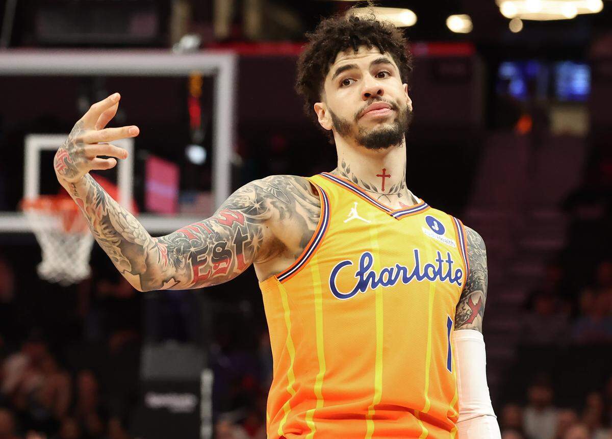 Charlotte Hornets guard LaMelo Ball signals his made 3-point basket to a Memphis Grizzlies defender during Saturday’s action at Spectrum Center.