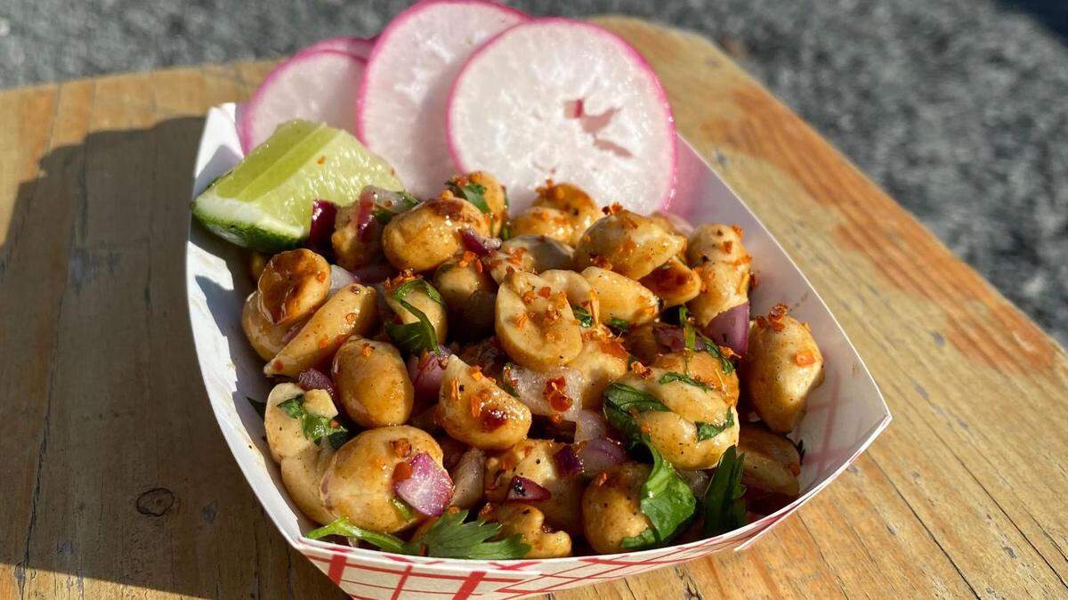 The Hangar’s Deez Nuts come with warm peanuts, hop honey, onion, cilantro, tajin, radish and a lime wedge.