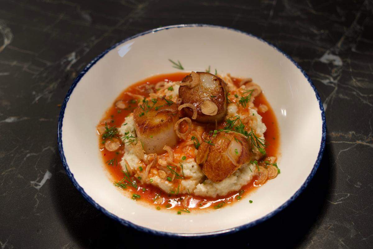 Henrietta’s scallops with Anson Mills grits, tomato brodo and crispy shallot.