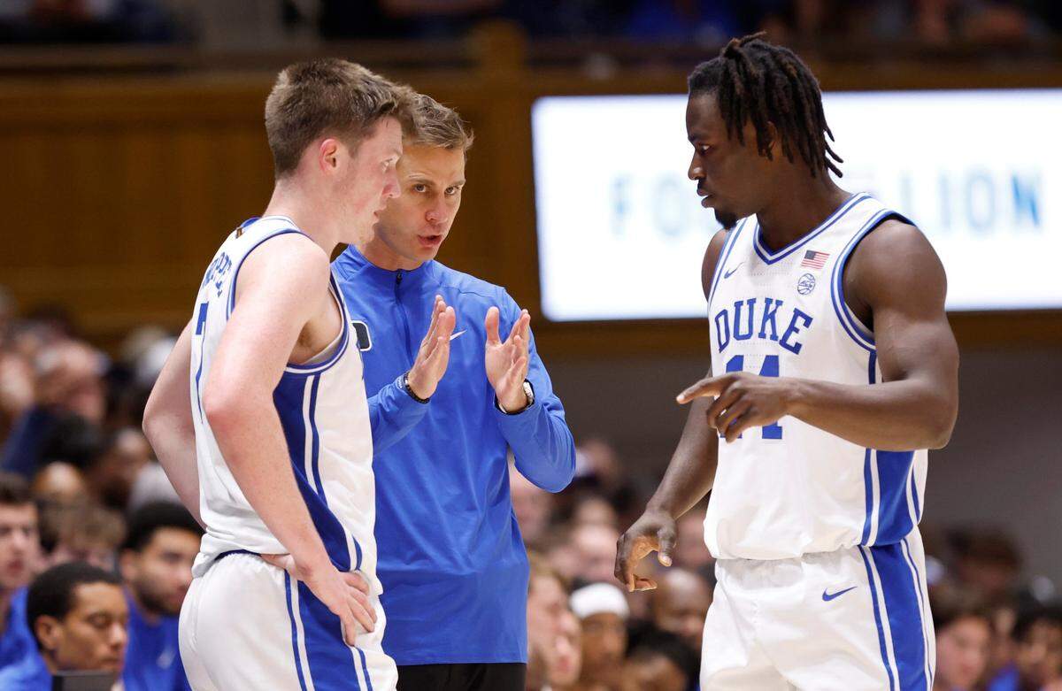 Duke head coach Jon Scheyer talks with Kon Knueppel (7) and Sion James (14) during the first half of Duke's Oct. 19, 2024, exhibition game against Lincoln (Pa) University at Cameron Indoor Stadium.
