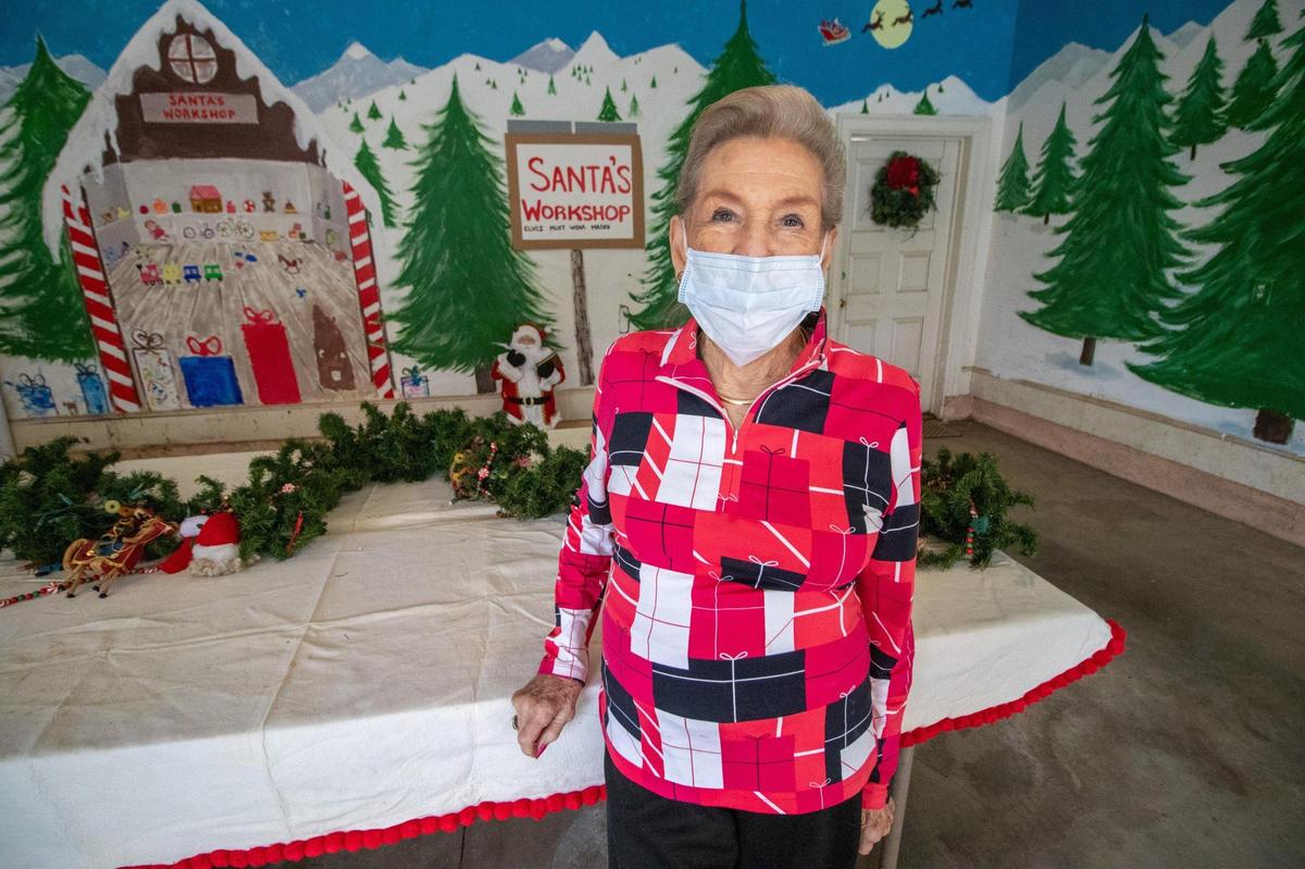 Gwin Dalton stands in her Alpine-themed garage, where banquet tables are set for family members to pick up food in disposable containers on Christmas Day.