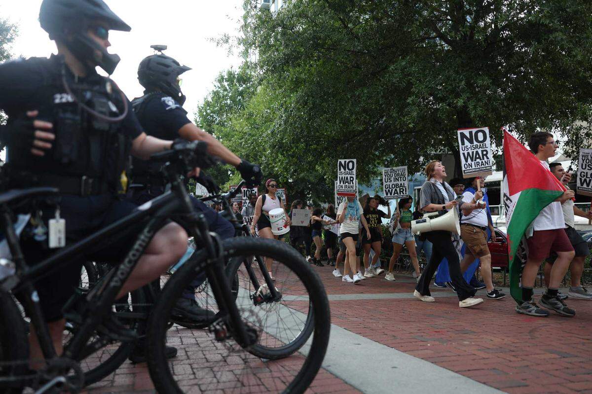 Police watch as protesters march for ‘No War on Iran!’ at Romare Bearden Park in Charlotte on Thursday.