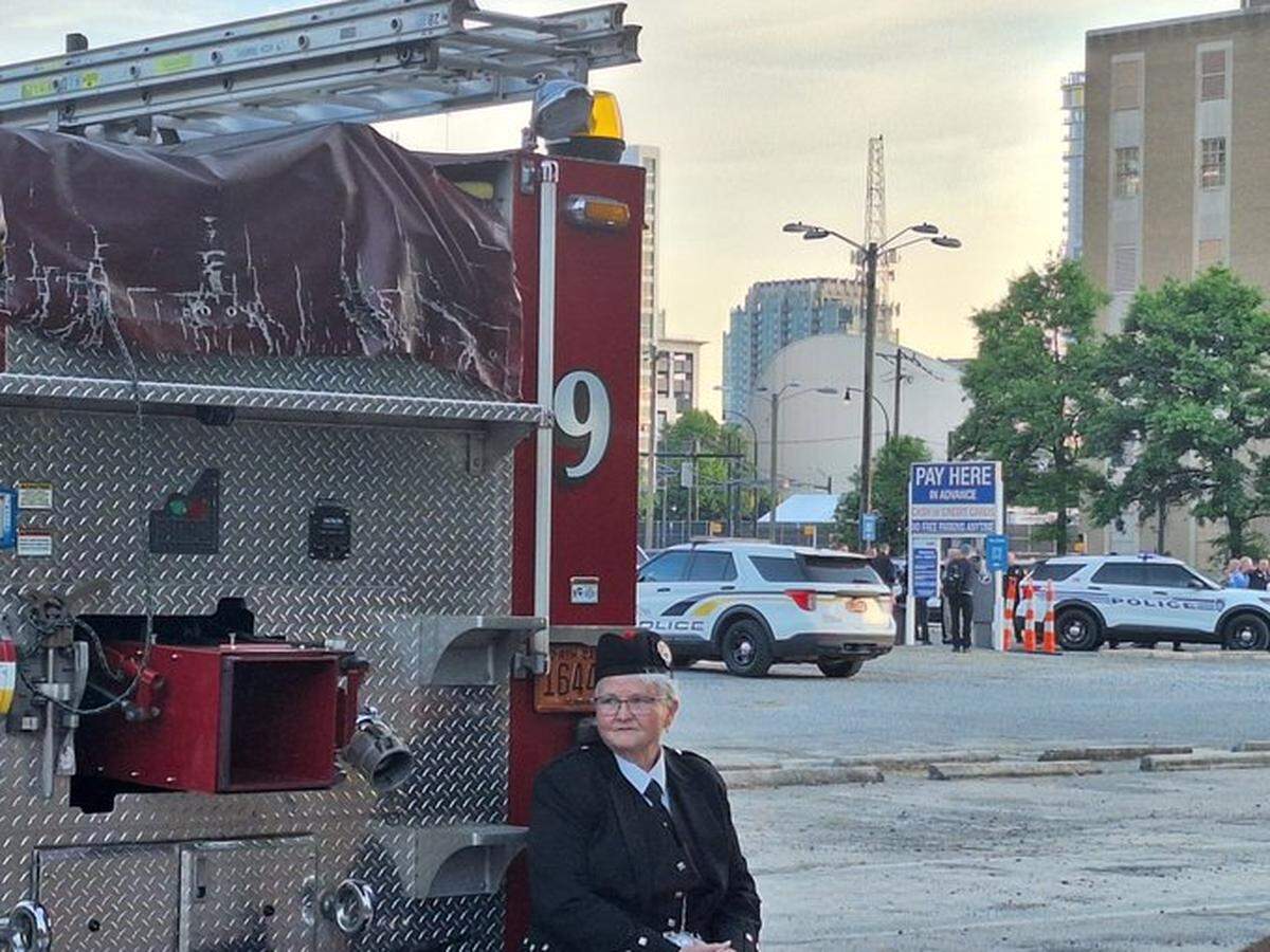 The first police and firefighters, and piper Melanye Brennan have arrived in a parking lot across from Charlotte-Mecklenburg Police Department headquarters for the processional for CMPD Officer Joshua Eyer.