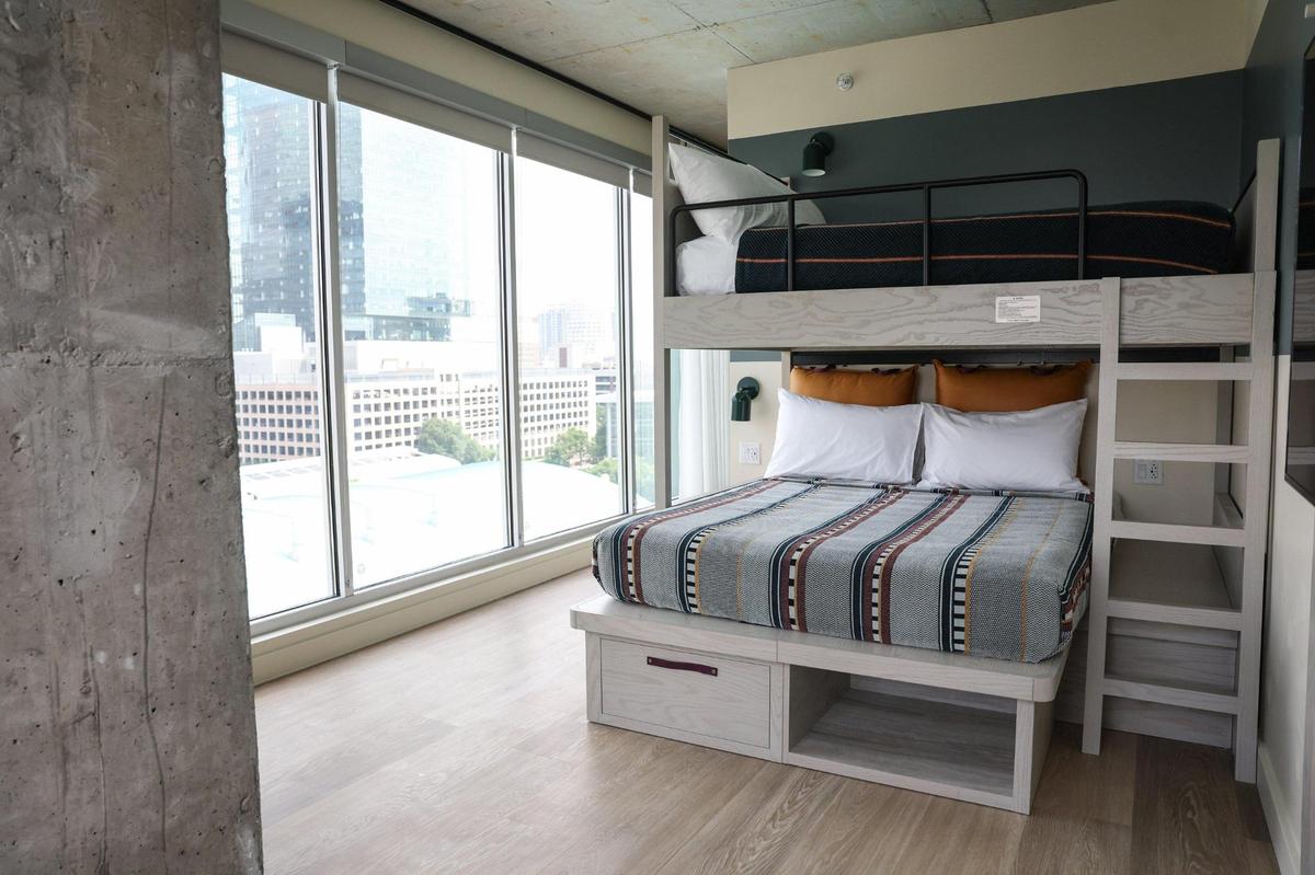 This room at the Moxy Charlotte Downtown has a bunk bed with two queen beds, encouraging group travel for friend trips.