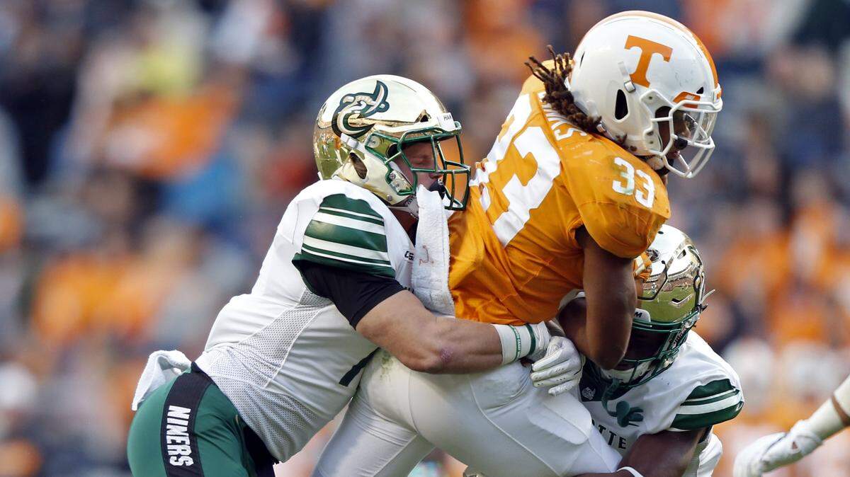 Tennessee running back Jeremy Banks (33) is tackled by Charlotte linebacker Luke Martin (17) and defensive back Ed Rolle (2) in the second half on Saturday in Knoxville. Tennessee won 14-3, but the 49ers were dominant defensively.