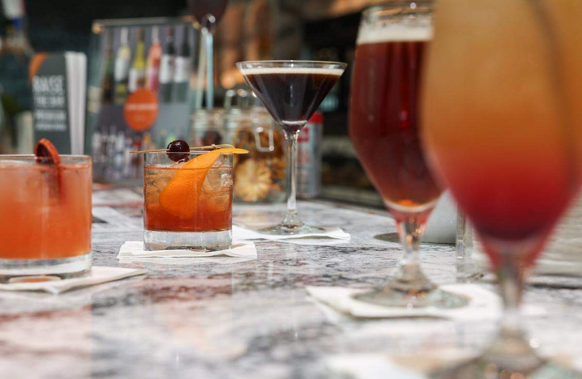 An old-fashioned sits among other craft cocktails at the bar inside the Delta Sky Club in Charlotte.