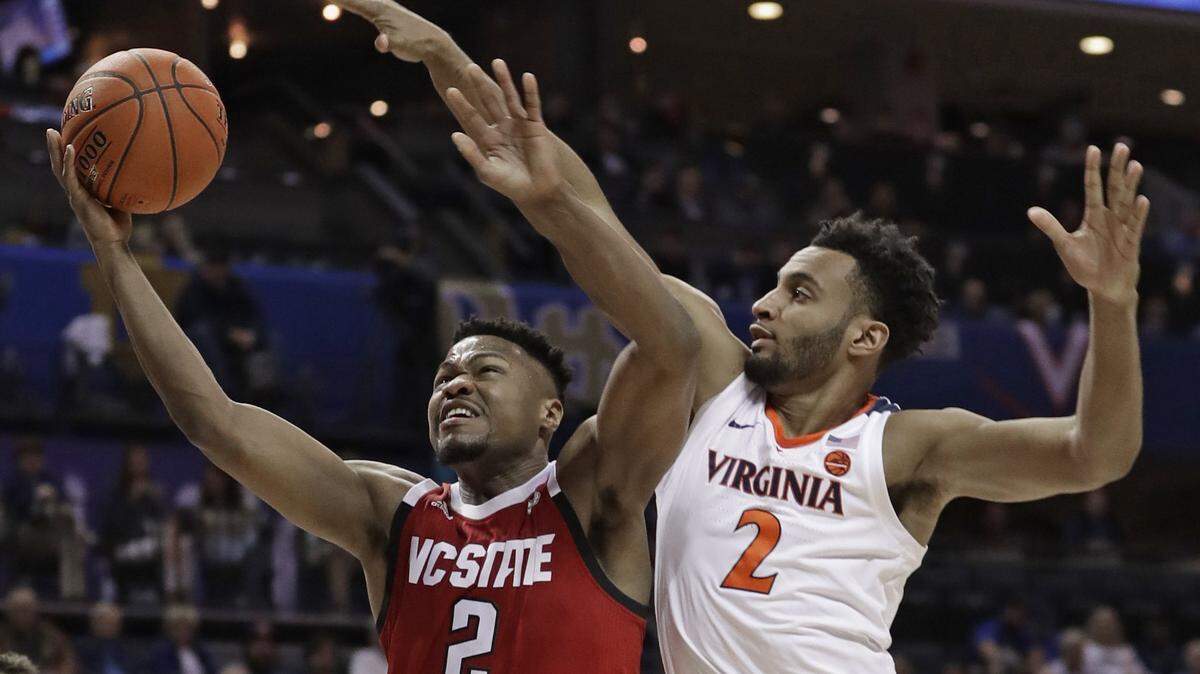 Virginia and Braxton Key, right, held N.C. State’s Torin Dorn to just seven points on Thursday. Key and Dorn are from Charlotte.