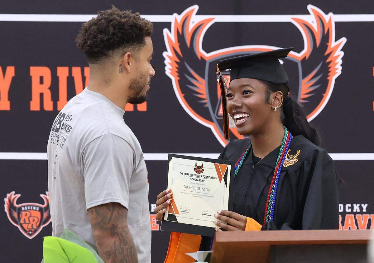 NFL defensive back Jaire Alexander, left, presents Rocky River High School student-athlete Nicole Johnson, right, with The Jaire Alexander Foundation Scholarship on Tuesday, May 19, 2026.