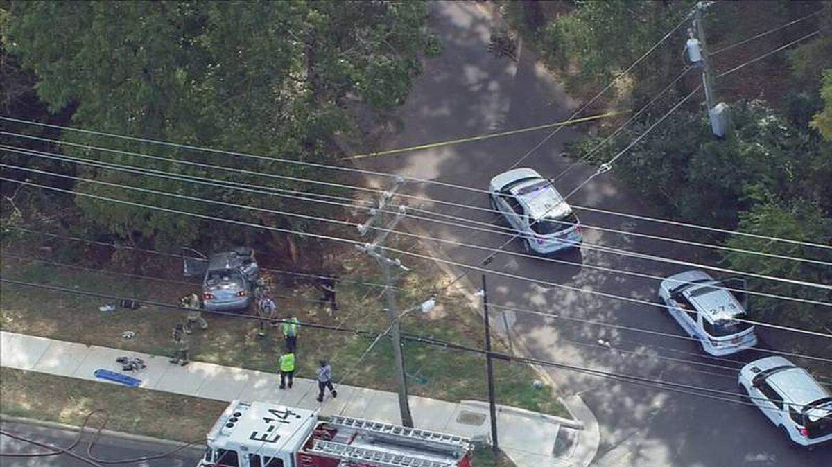 In this image from WSOC’s helicopter, firefighters and police tend to a crash that killed one person and left another seriously injured in southeast Charlotte, N.C., on Monday, October 3, 2022.