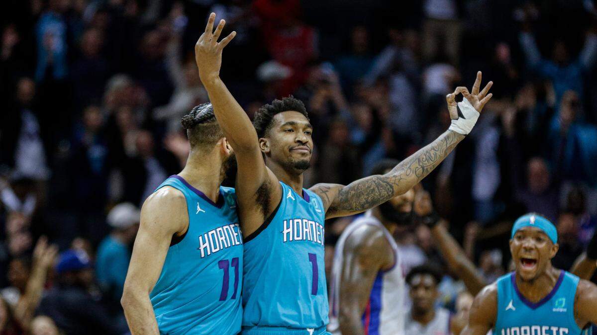 Charlotte Hornets guard Malik Monk, center, celebrates his 3-point game-winner over the Detroit Pistons, surrounded by teammates Cody Martin (left) and Devonte Graham (right).