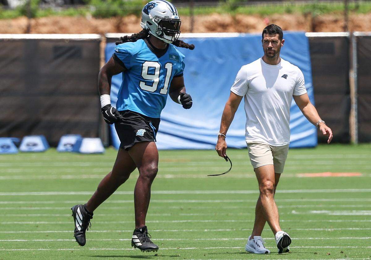 Panthers linebacker Patrick Jones II, left, and head coach Dave Canales walk to the team scrimmage during the second day of minicamp in Charlotte, NC on Wednesday, June 11, 2025.